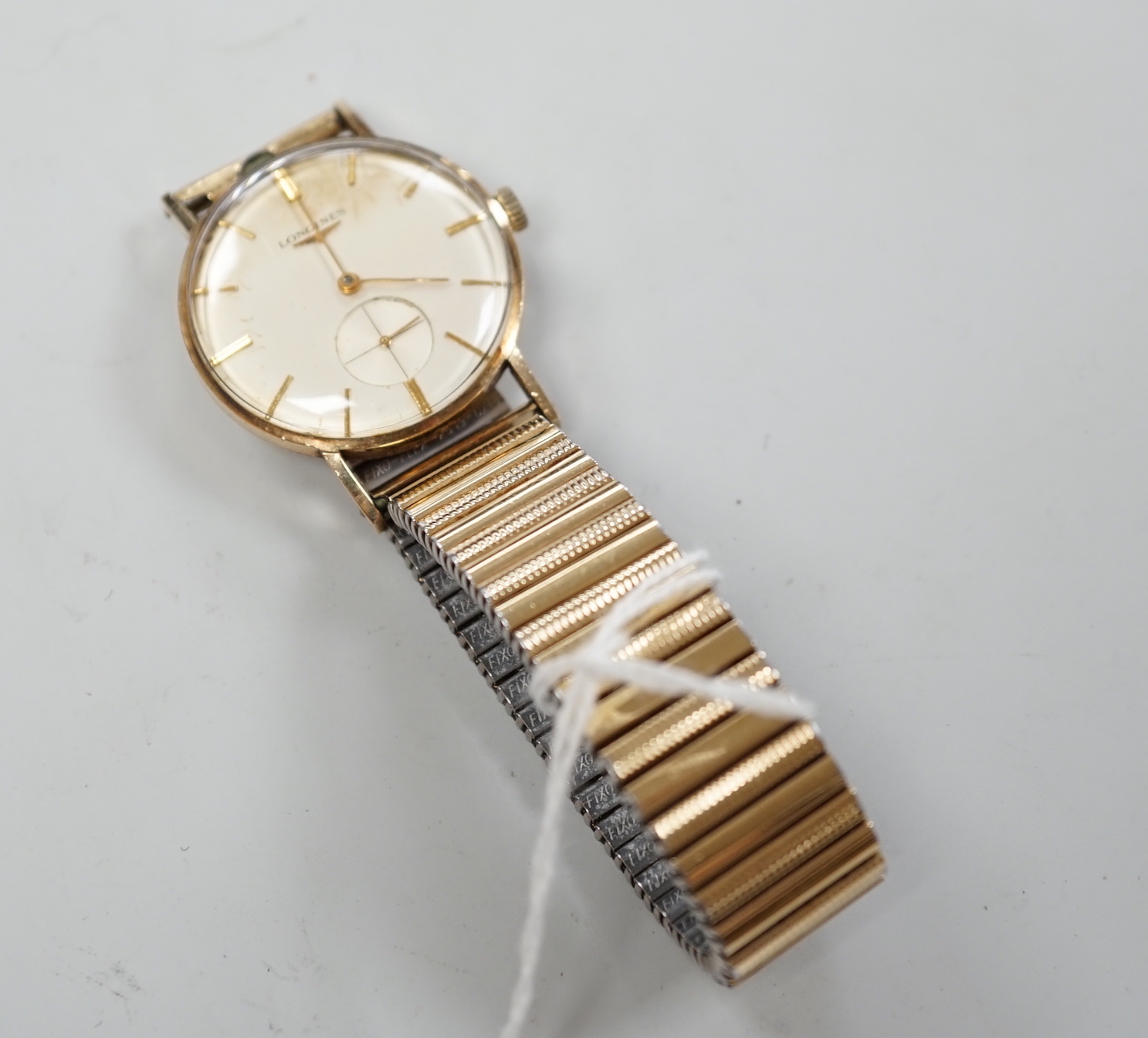 A gentleman's 9ct. gold Longines manual wind wrist watch, with engraved inscription, on an associated strap, boxed.
